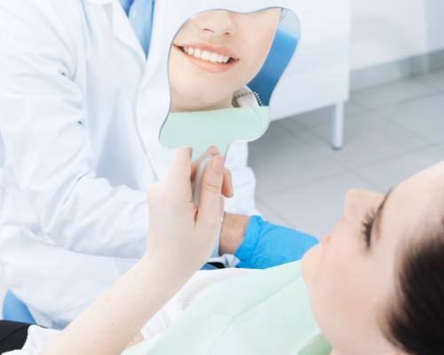 Patient examining her dental restoration in a mirror